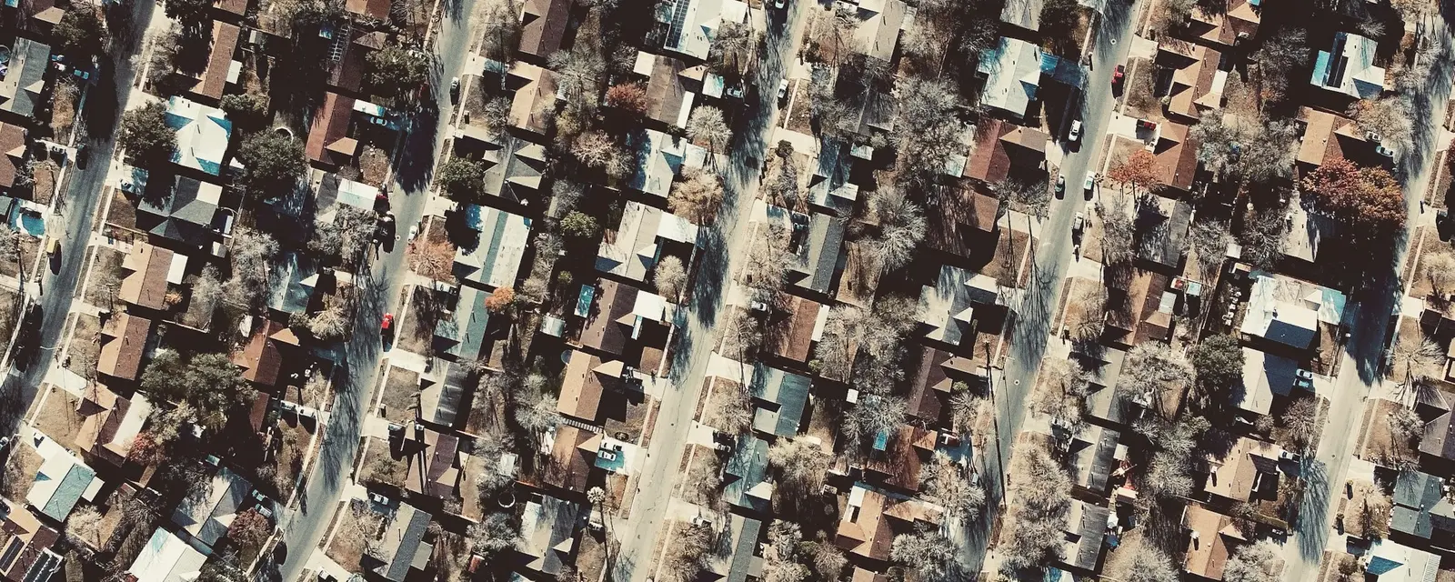 An aerial view of homes, tree-lined streets and rooftops across a neighborhood.